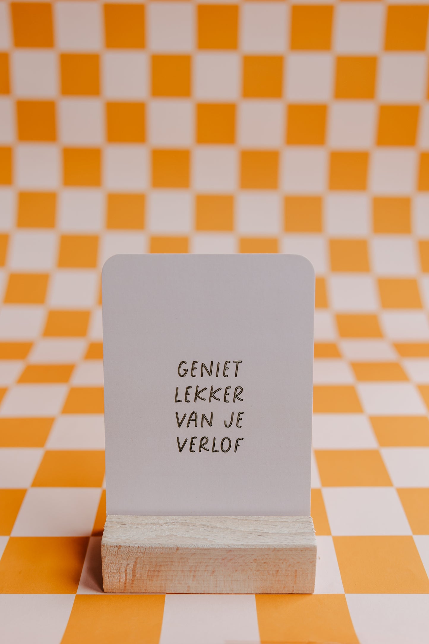 Witte wenskaart met de tekst "Geniet lekker van je verlof" in een stijlvol lettertype. Gedrukt op stevig papier en geleverd met een kraft envelop.